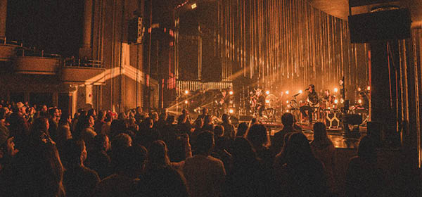 an audience standing, engaged in the show performing on The Hanover Theatre stage